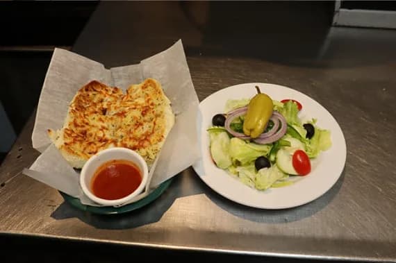 Garlic bread with marinara dipping sauce and a side salad