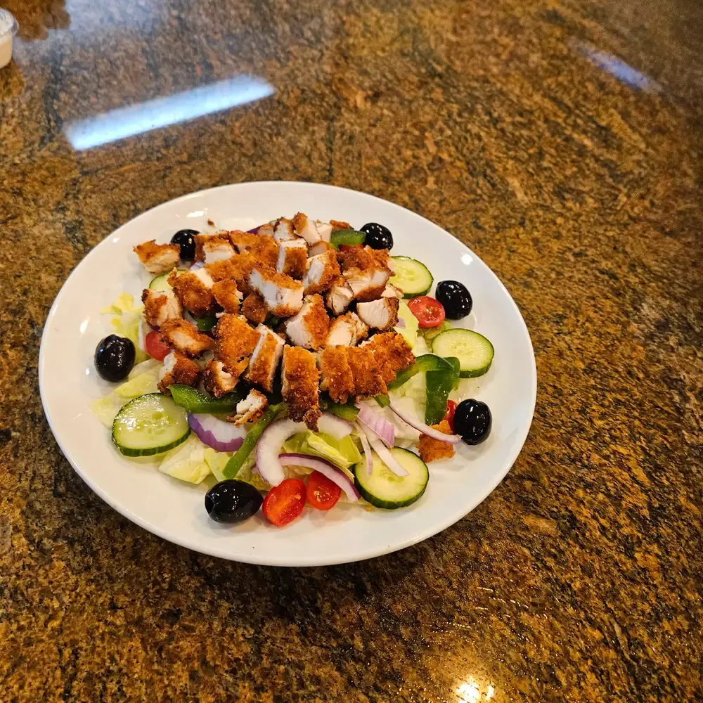 Crispy chicken salad with cucumbers, olives, tomatoes and red onion